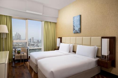 Gulta vai gultas numurā naktsmītnē La Suite Dubai Hotel & Apartments