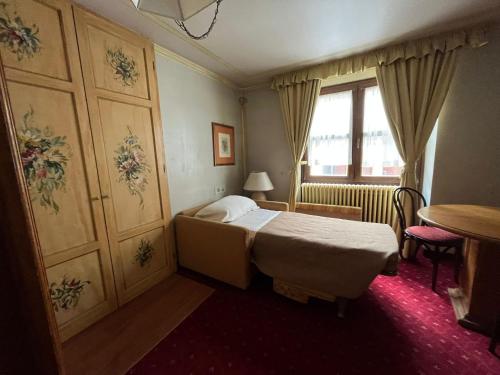 - une petite chambre avec un lit et une fenêtre dans l'établissement Hotel Posta R.T.A., à Madonna di Campiglio