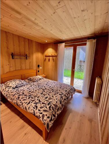 een slaapkamer met een bed en een groot raam bij Résidences Delavay La Cordée in Les Gets