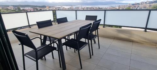 een houten tafel en stoelen op een balkon bij Palazzu B reservation 3 nuits minimum in Ajaccio