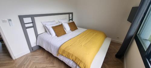 een slaapkamer met een bed met een gele deken erop bij Palazzu B reservation 3 nuits minimum in Ajaccio