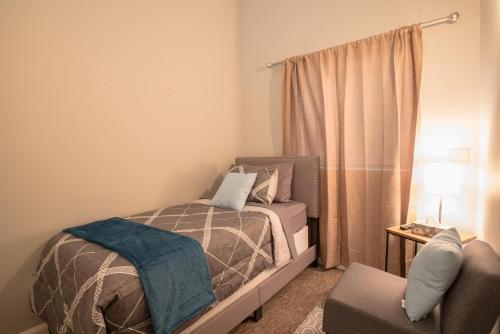 1 dormitorio pequeño con 1 cama y 1 silla en Girlfriend Getaway Suite, en Nashville