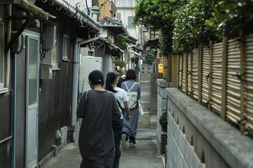 呉市にあるゲストハウス 瀬戸内ライフの路地を歩く人々