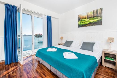 1 dormitorio con cama grande y ventana grande en Ach Mazury, en Mikołajki