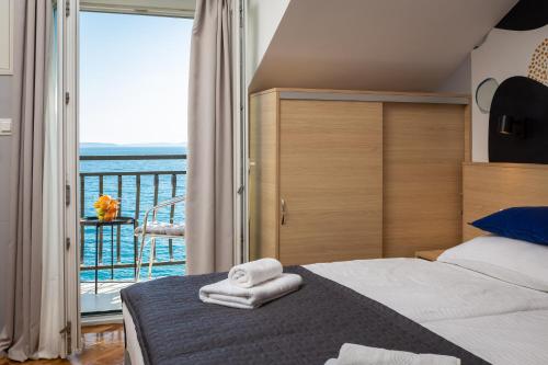 um quarto com uma cama e vista para o oceano em Solar Beach Inn em Split