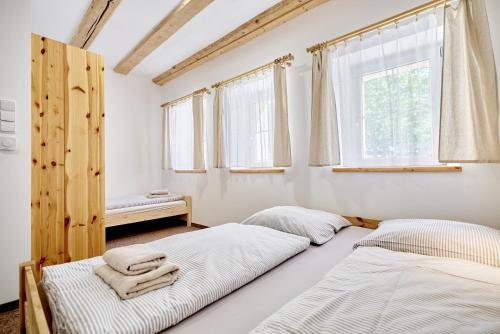 two beds in a room with two windows at Pension Barborka in Boží Dar