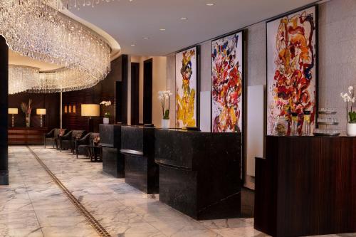 un vestíbulo del hotel con un bar con sillas y pinturas en JW Marriott Hotel Frankfurt, en Frankfurt