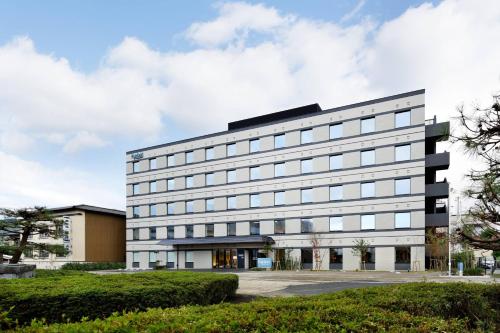 um grande edifício branco com muitas janelas em Fairfield by Marriott Kyoto Amanohashidate em Miyazu