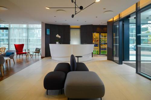 un hall avec des chaises et un comptoir dans un bâtiment dans l'établissement Residence Inn by Marriott Toulouse-Blagnac, à Blagnac