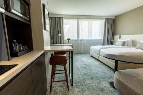 Cette chambre comprend un lit, un bureau et une table. dans l'établissement Residence Inn by Marriott Toulouse-Blagnac, à Blagnac