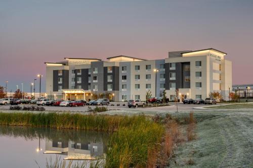 un gran edificio con coches estacionados en un estacionamiento en TownePlace Suites by Marriott Indianapolis Airport, en Indianápolis