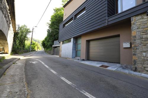 une rue vide à côté d'un bâtiment avec garage dans l'établissement Aux Berges du Bocq, à Yvoir