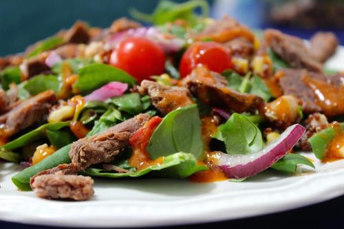 a salad with meat and vegetables on a white plate at Royal in Deventer