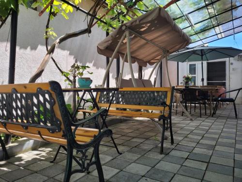 a couple of benches and an umbrella on a patio at Vila Didi, Mangalia in Mangalia