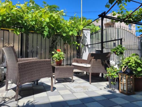 a patio with wicker chairs and tables and plants at Vila Didi, Mangalia in Mangalia