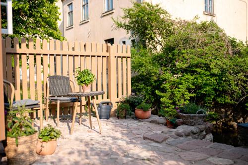 un patio con mesa, sillas y una valla en i’dille Brīvdienu māja, en Kuldīga