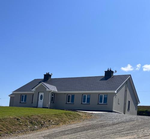 een groot wit huis op een onverharde weg bij The Collins,Our View from The Top in Listowel