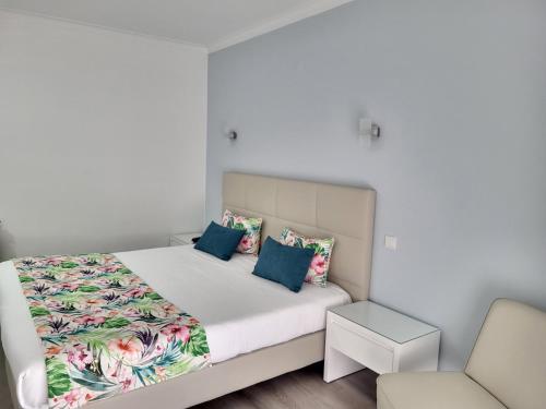 um quarto com uma cama e uma cadeira em Hotel Ancora Mar na Nazaré