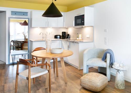 - une cuisine et une salle à manger avec une table et des chaises dans l'établissement Seehuus Duhnen Apartments, à Cuxhaven