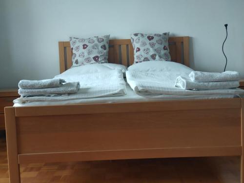 1 cama con 2 almohadas y toallas en Rooms and Apartment Na poljani, en Škofja Loka