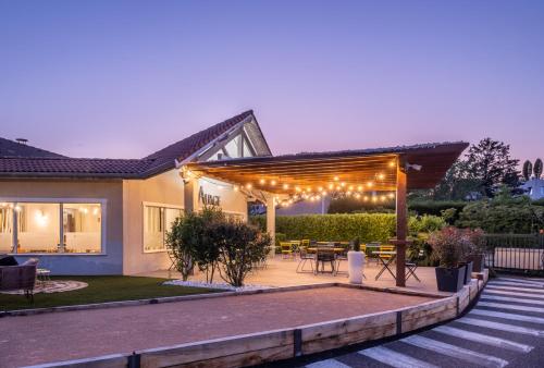 une arrière-cour avec une pergola éclairée dans l'établissement Kyriad Lyon Est - Bron Eurexpo Le Cottage, à Bron