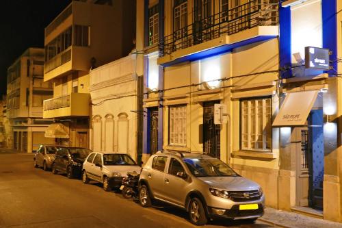 uma fila de carros estacionados numa rua da cidade à noite em Guest House Sao Filipe em Faro