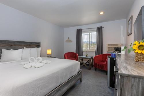 Cette chambre comprend un lit, un bureau et des chaises. dans l'établissement RiverWalk Inn, à Pagosa Springs