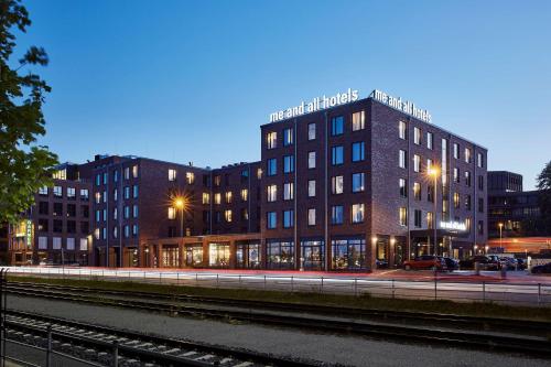 基尔Me and All Hotel Kiel, by Hyatt的毗邻火车轨道的建筑物