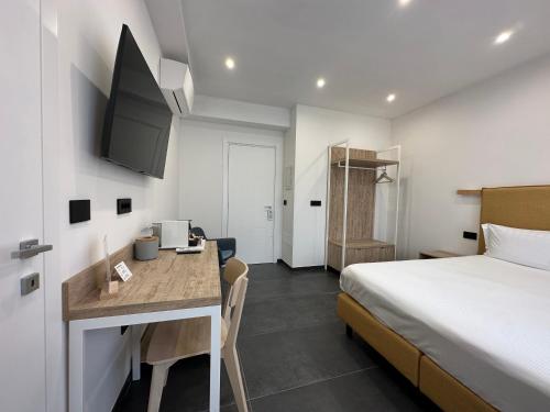 een hotelkamer met een bed, een bureau en een keuken bij NG Guest House il Gallura in Olbia