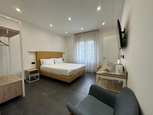 een hotelkamer met een bed en een stoel bij NG Guest House il Gallura in Olbia