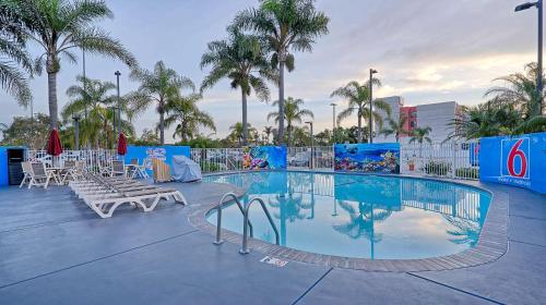 einen großen Pool mit Stühlen und Palmen in der Unterkunft Suites Los Angeles CA Los Angeles LAX in Inglewood