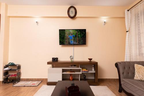 salon z kanapą i zegarem na ścianie w obiekcie Luxurious-2 bedroom Furnished Apartment w mieście Nairobi