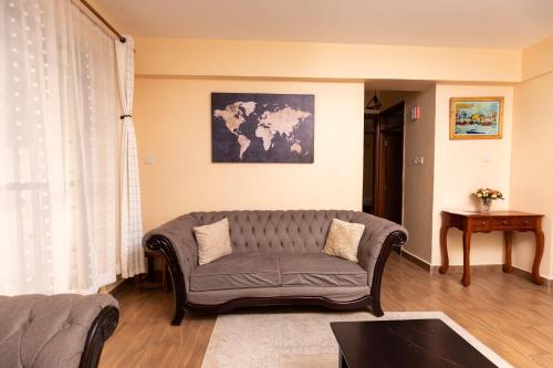 salon z kanapą i mapą na ścianie w obiekcie Luxurious-2 bedroom Furnished Apartment w mieście Nairobi