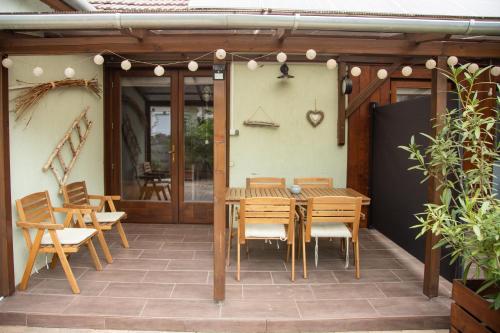 a wooden table and chairs on a patio at Csillagvirág Apartman Gyula in Gyula