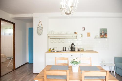 a kitchen and dining room with a table and chairs at Csillagvirág Apartman Gyula in Gyula