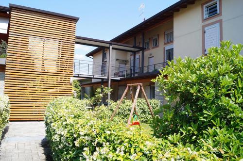 einen Garten mit einer Schaukel vor einem Haus in der Unterkunft Charme Lake Loft in Ispra