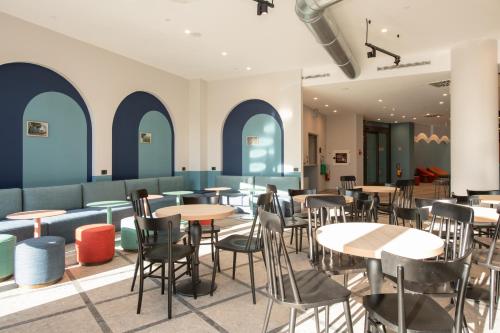 a restaurant with tables and chairs and blue walls at MEININGER Venezia Mestre in Mestre