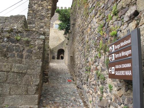 un callejón de piedra con una señal en el lateral de un edificio en Casa do Castelo - Torre, en Castelo de Vide