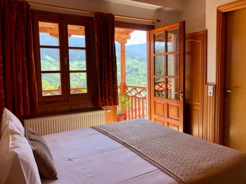 una camera con un letto e una grande finestra di Apostolos Hotel a Metsovo