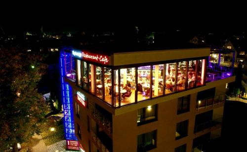 a building with lights in the windows at night at EINSTEIN Hotel am Römerpark in Andernach