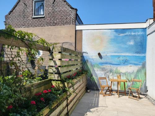 un mural en el lateral de una casa con mesa y sillas en Boutique Hotel Huys van Leyden, en Leiden