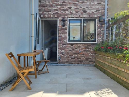 un patio con una mesa de madera y un banco en Boutique Hotel Huys van Leyden, en Leiden