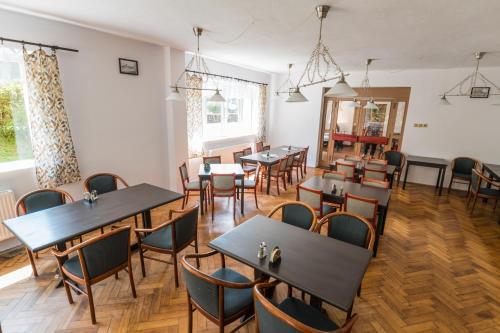 a restaurant with tables and chairs in a room at Chata Čeňkovka in Srní