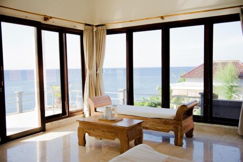 Camera con letto, tavolo e finestre di Alam Bali Beach Resort ad Amed