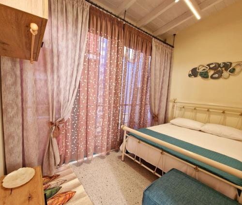 a bedroom with a bed and a window with curtains at Alkionisnest in Arkoudi