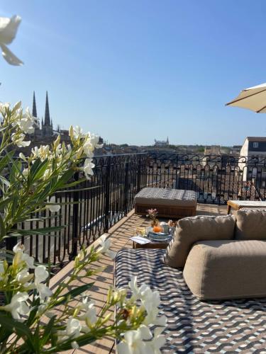 a balcony with couches and a view of a city at Hôtel Singulier Bordeaux - Boutique Hôtel & Spa Anne Semonin in Bordeaux