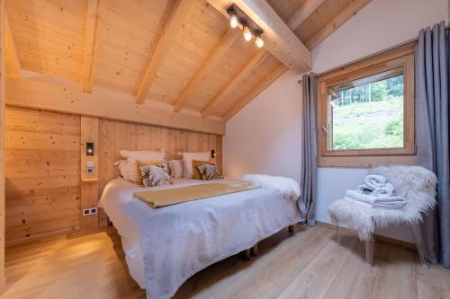 莫尔济讷Appartements Chalet Le Fornay的小木屋内的卧室,配有床和窗户