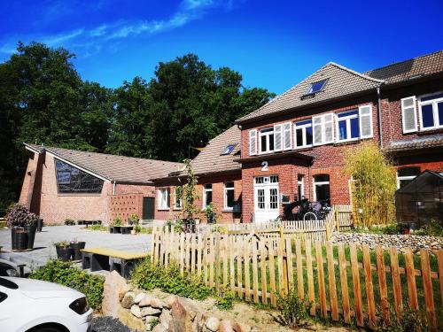 ein Haus mit einem Holzzaun davor in der Unterkunft Gästehaus Maria Rast in Suderburg