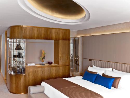 um quarto com uma cama grande e almofadas azuis em The St. Regis Istanbul em Istambul