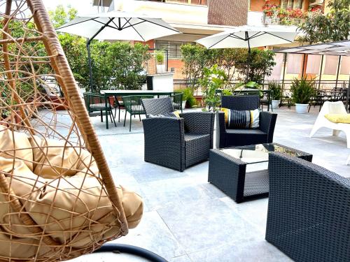 een patio met stoelen, tafels en parasols bij Hotel Franchi in Florence